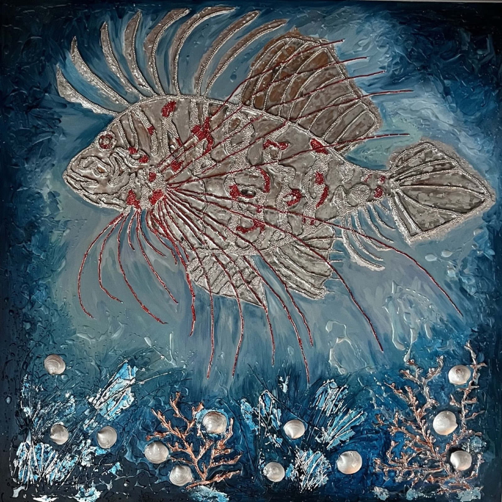 Lionfish in silver and red relief over a blue underwater scene with pearls and corals