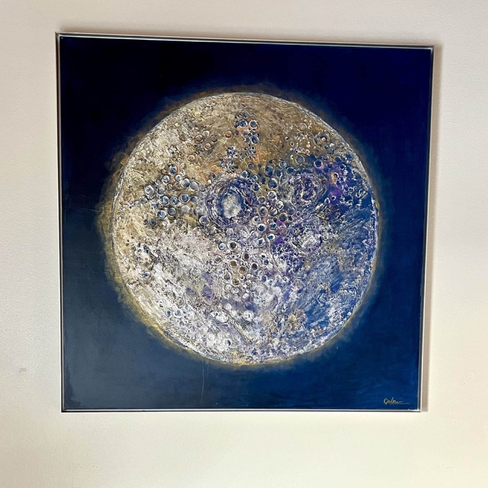 Textured painting of a full moon in silver and gold on a deep blue ground